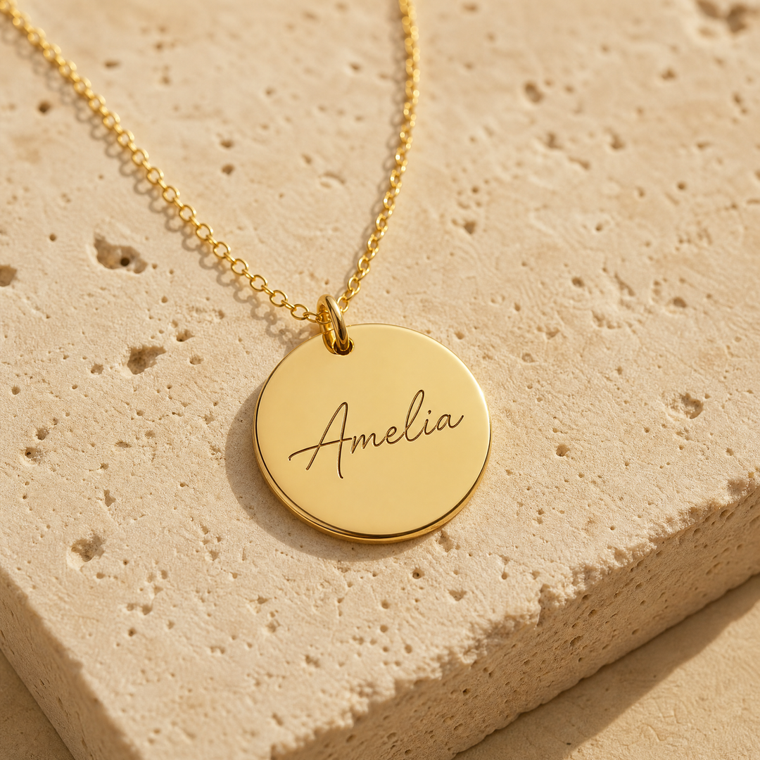 Gold disc necklace engraved with a name in script