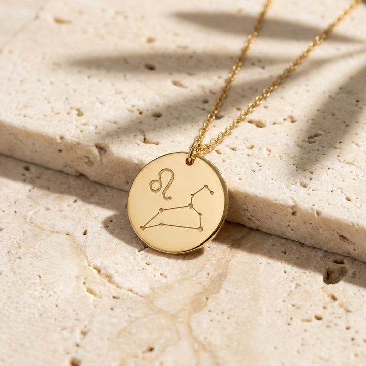Gold zodiac necklace engraved with the Leo symbol and constellation